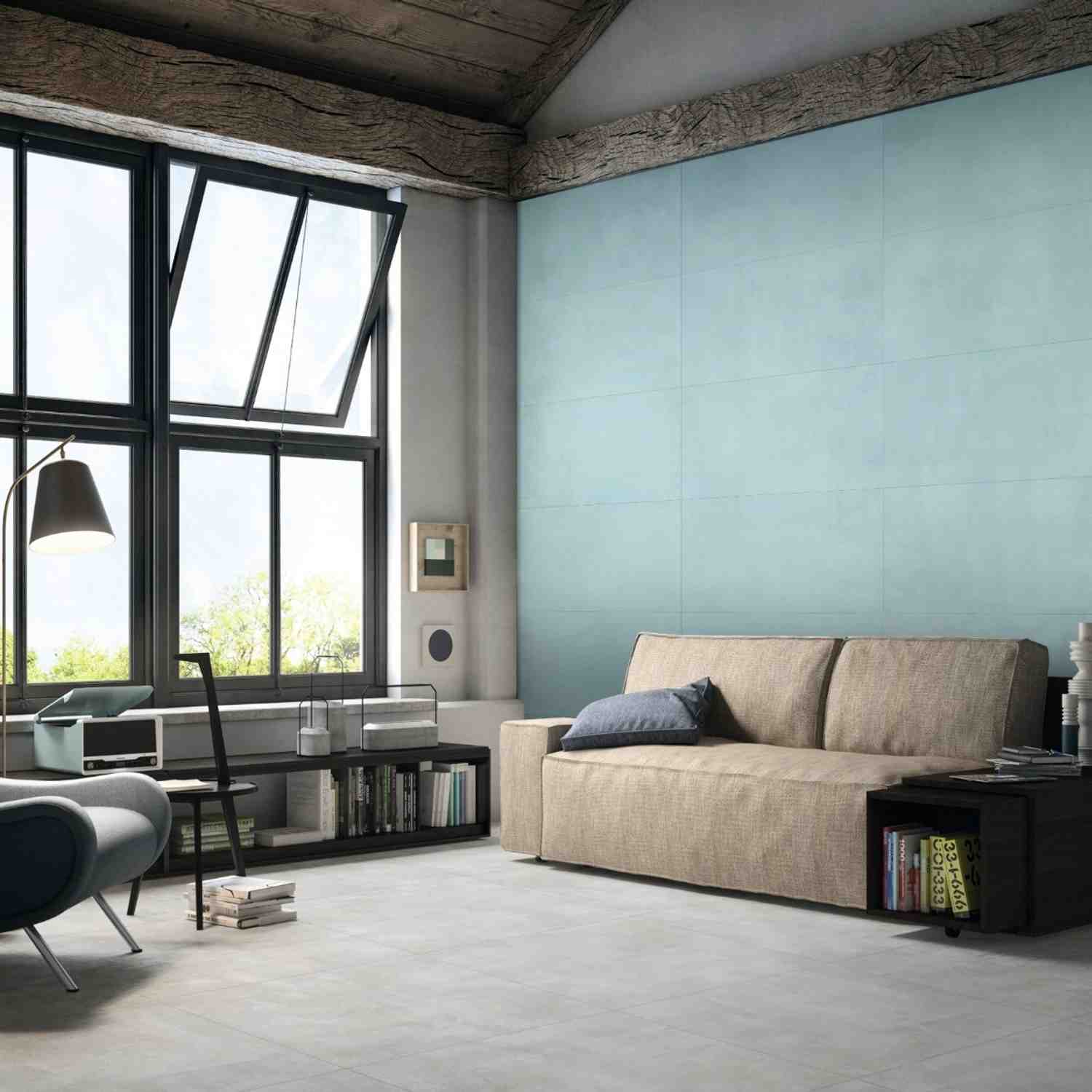Florina Urban Cement porcelain wall tiles in light aqua mint in a loft-style living room with large industrial windows, beige sofa, pendant lamp, and exposed concrete ceiling