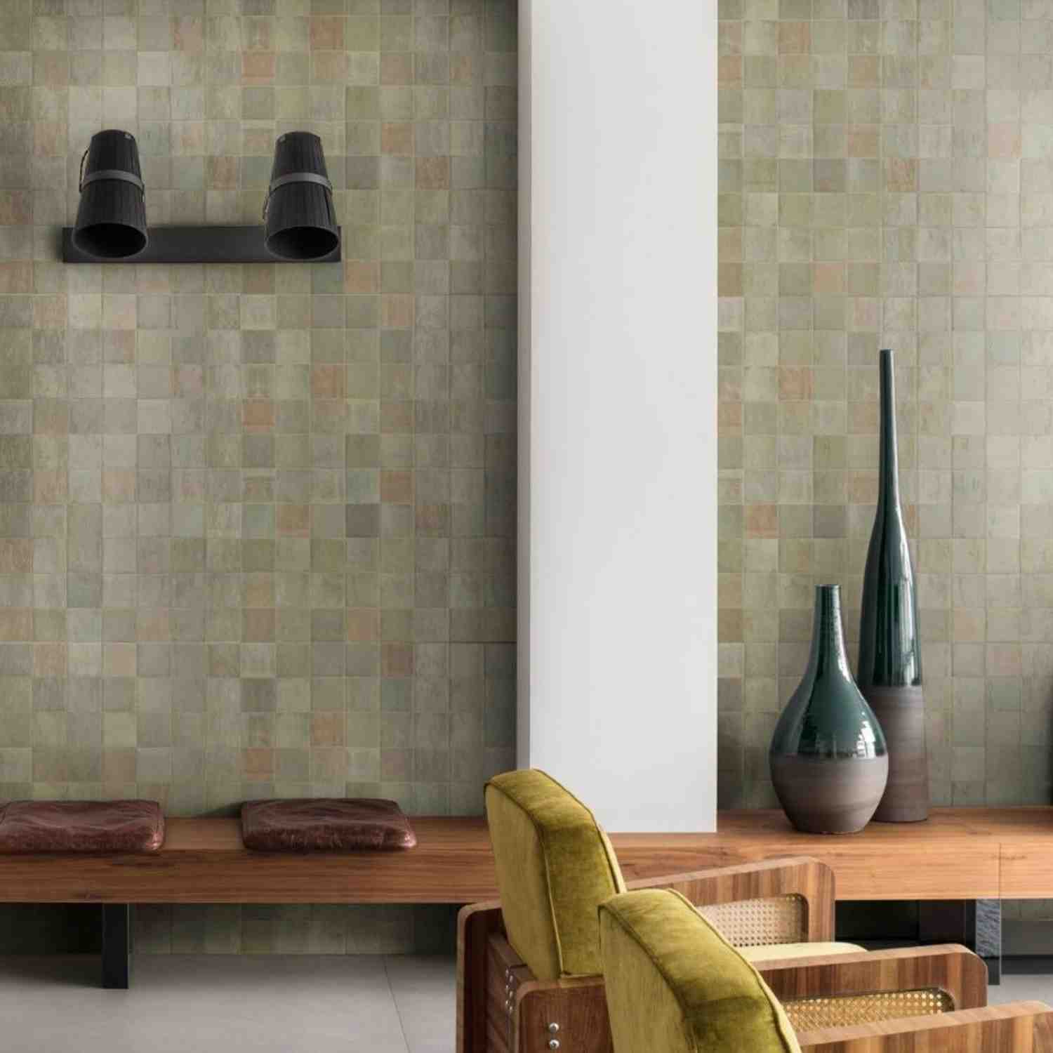 Marazzi Zellige glossy ceramic wall tiles in olive green in entryway with wall-mounted spotlight, decorative ceramic vases, wooden bench, and green velvet chair
