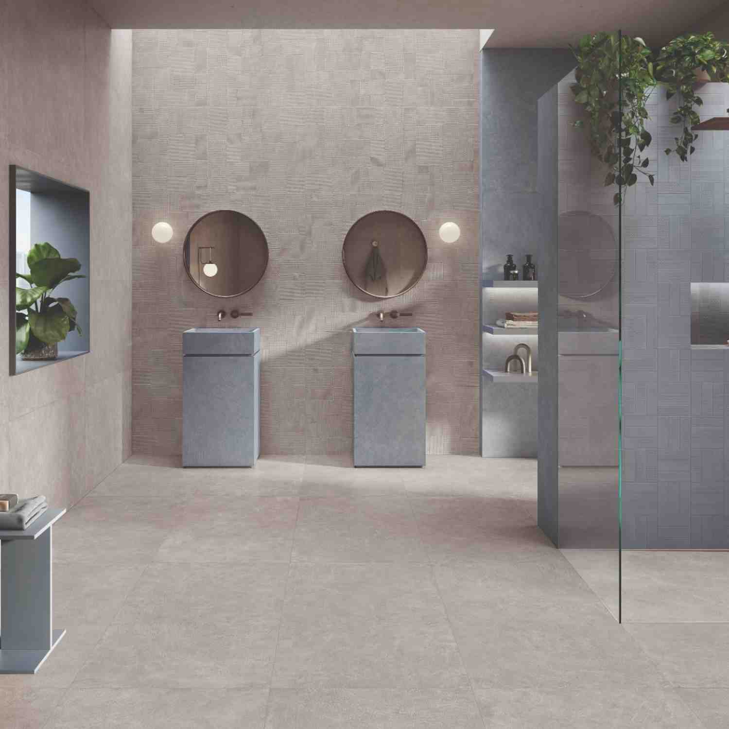 Sixty beige porcelain tile in modern double vanity bathroom with round mirrors, gray sinks, and trailing plants